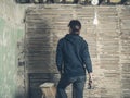 Woman standing on stepladder by wattle and daub wall