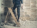 Woman standing on stepladder by wattle and daub wall Royalty Free Stock Photo