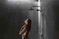 Woman taking shower in dark modern bathroom interior Royalty Free Stock Photo