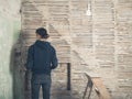 Young woman by wattle and daub wall