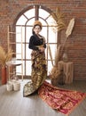 young woman wearing long woven cloth and black Balinese Kebaya