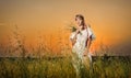 Young woman standing on a wheat field with sunrise on the background Royalty Free Stock Photo