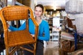 woman standing with wicker chair in shop for decor Royalty Free Stock Photo