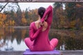 Young woman standing in yoga posture on wooden bridge in autumn Royalty Free Stock Photo