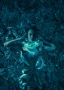 Young woman stands in cosmic image of extraterrestrial goddess with shiny body art and neon lights Royalty Free Stock Photo