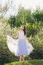 Young woman stands on a hill against the background of flowering trees Royalty Free Stock Photo