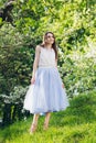 Young woman stands on a hill against the background of flowering trees Royalty Free Stock Photo