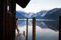 Young woman stands by lake surrounded by mountains at sunset. Royalty Free Stock Photo