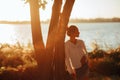 Woman stands near tree against river background Royalty Free Stock Photo
