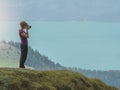 Young woman making pictures on top of a mountain Royalty Free Stock Photo