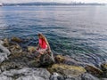 A young woman stands in the water of the Sea of Marmara on the embankment of Istanbul Turkey. Adult European blonde girl on the