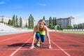 A young woman in the starting position for running on a sports track Royalty Free Stock Photo
