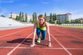 A young woman in the starting position for running on a sports track Royalty Free Stock Photo