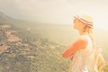 Young woman stay at edge of cliff looking over expansive view of plains and mountains Royalty Free Stock Photo