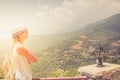 Young woman stay at edge of cliff looking over expansive view of plains and mountains Royalty Free Stock Photo