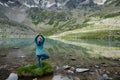 Young woman stays in one leg yoga position against the turquoise lake in the mountains Royalty Free Stock Photo