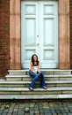Young woman on steps in front of door