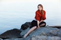 Young woman on stones near water Royalty Free Stock Photo