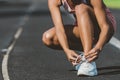 A young woman stopped to tie a string while running in the stadium Royalty Free Stock Photo