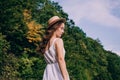 Young woman in a straw hat on a background of green summer forest. Beautiful girl in a dress with a bouquet of dried flowers Royalty Free Stock Photo