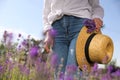 Young woman with straw hat and lavender bouquet in field on summer day Royalty Free Stock Photo