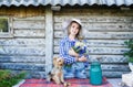 Young woman in a straw summer hat and her small dog rural background Royalty Free Stock Photo