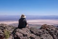 Young woman in a stray hat sitting on a cliff overlooking Alvord Desert Royalty Free Stock Photo