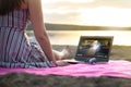 Young woman streaming a movie with laptop computer on beach. Royalty Free Stock Photo