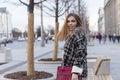 Young woman on the street of the city. Beautiful smiling blonde in a warm stylish coat