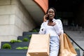 Young african woman at the street with shopping bags talking on mobile phone Royalty Free Stock Photo