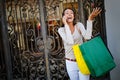 Young woman at the street with shopping bags talking on mobile phone Royalty Free Stock Photo