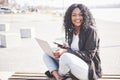 Young woman on the street working on laptop and talking on mobile phone Royalty Free Stock Photo