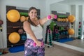 Young woman strengthening her hands using dumbbells