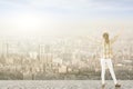 Young woman with stretched arms looking at city