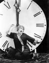 A young woman stretching in front of a giant clock striking midnight Royalty Free Stock Photo