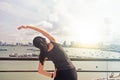 Young woman stretching her arms on pier in summer Royalty Free Stock Photo