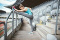 Young woman stretching outdoors and doing warm up exercises. Training and working out sportswoman concept Royalty Free Stock Photo