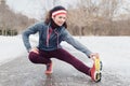 Young woman stretching and warming up for jogging outside in winter park Royalty Free Stock Photo