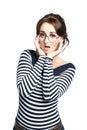 A young woman in a striped tight sweater, wearing round glasses, makes a regrettable face, Royalty Free Stock Photo