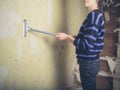 Young woman stripping wallpaper