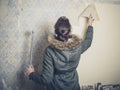 Young woman stripping wallpaper