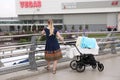 Young woman with a stroller for twins on the background of the shopping center Vegas . Moscow. 27.07.2018