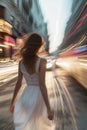 A young woman strolls through the bustling city street. Traffic light spots.