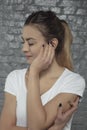 Young woman struggles with earache, hand in the place of pain, s