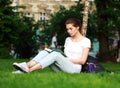 Young woman student in a city park reading a book Royalty Free Stock Photo