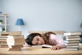 Young woman student with many books sleeping