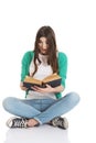 Young woman student sitting and reading a book. Royalty Free Stock Photo