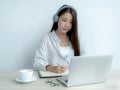 Young woman student taking notes watching laptop study online class video conference education elearning course from home Royalty Free Stock Photo