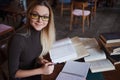 Young woman student of the University. Preparing exam and learning lessons in public library. Royalty Free Stock Photo