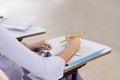 Young woman studying for a test, student hands writing in book at classroom. Learning and Education, college concept